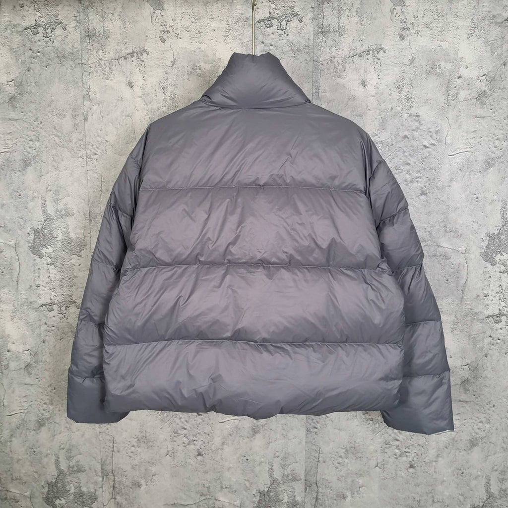 Gray Balenciaga puffer jacket back view with stand collar and quilted panels.