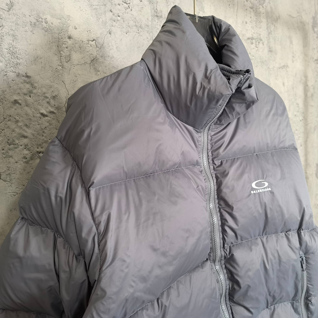 Gray Balenciaga puffer jacket side view with zip seam and small chest logo.