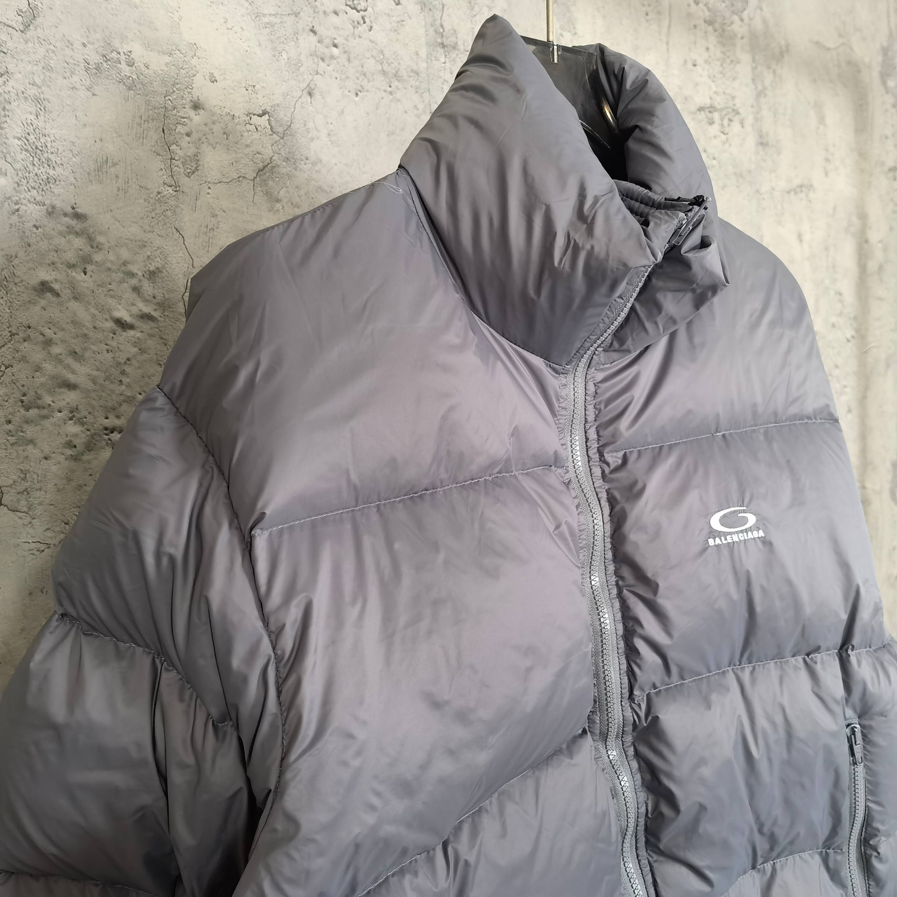 Gray Balenciaga puffer jacket side view with zip seam and small chest logo.