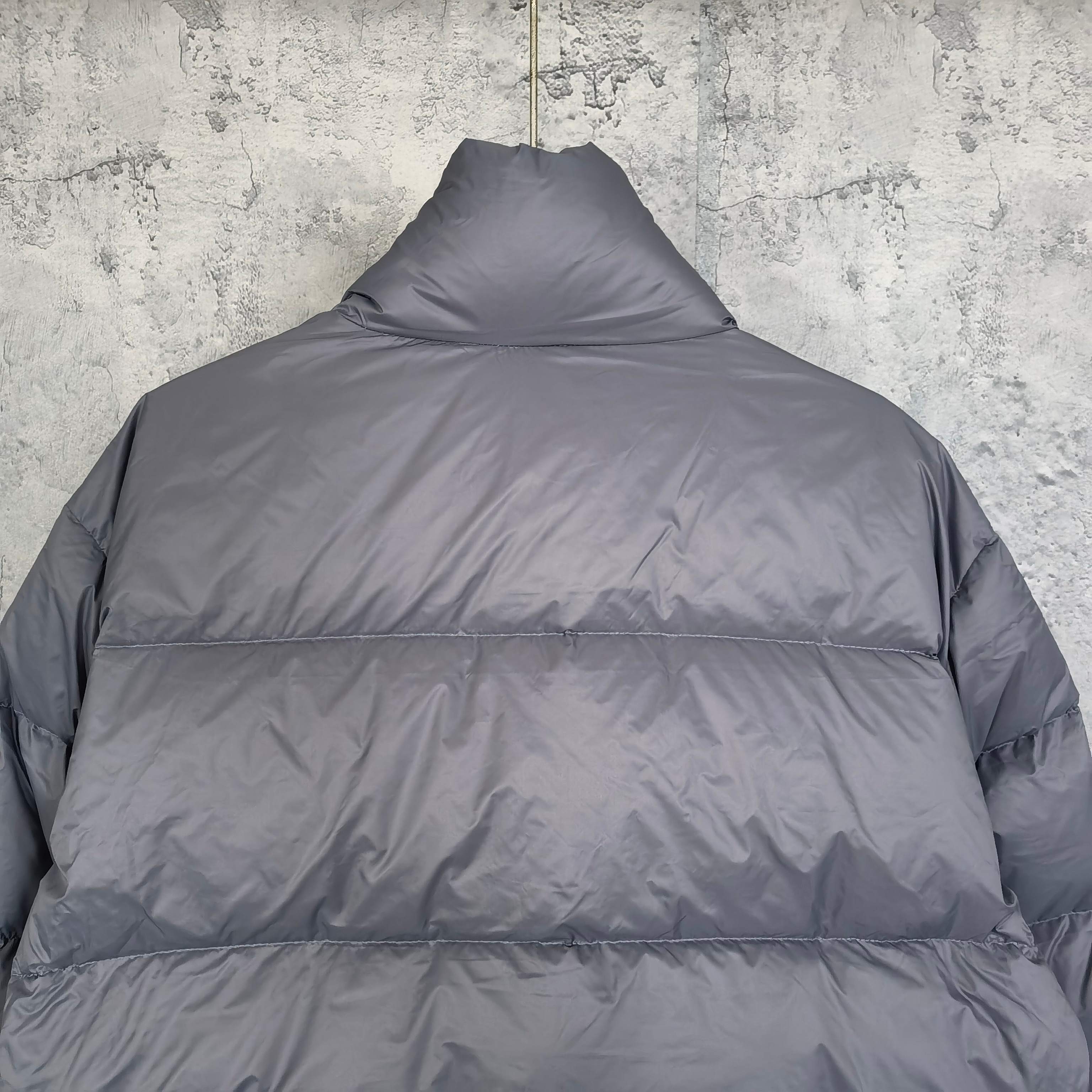 Gray Balenciaga puffer jacket back with stand collar and horizontal quilted panels.