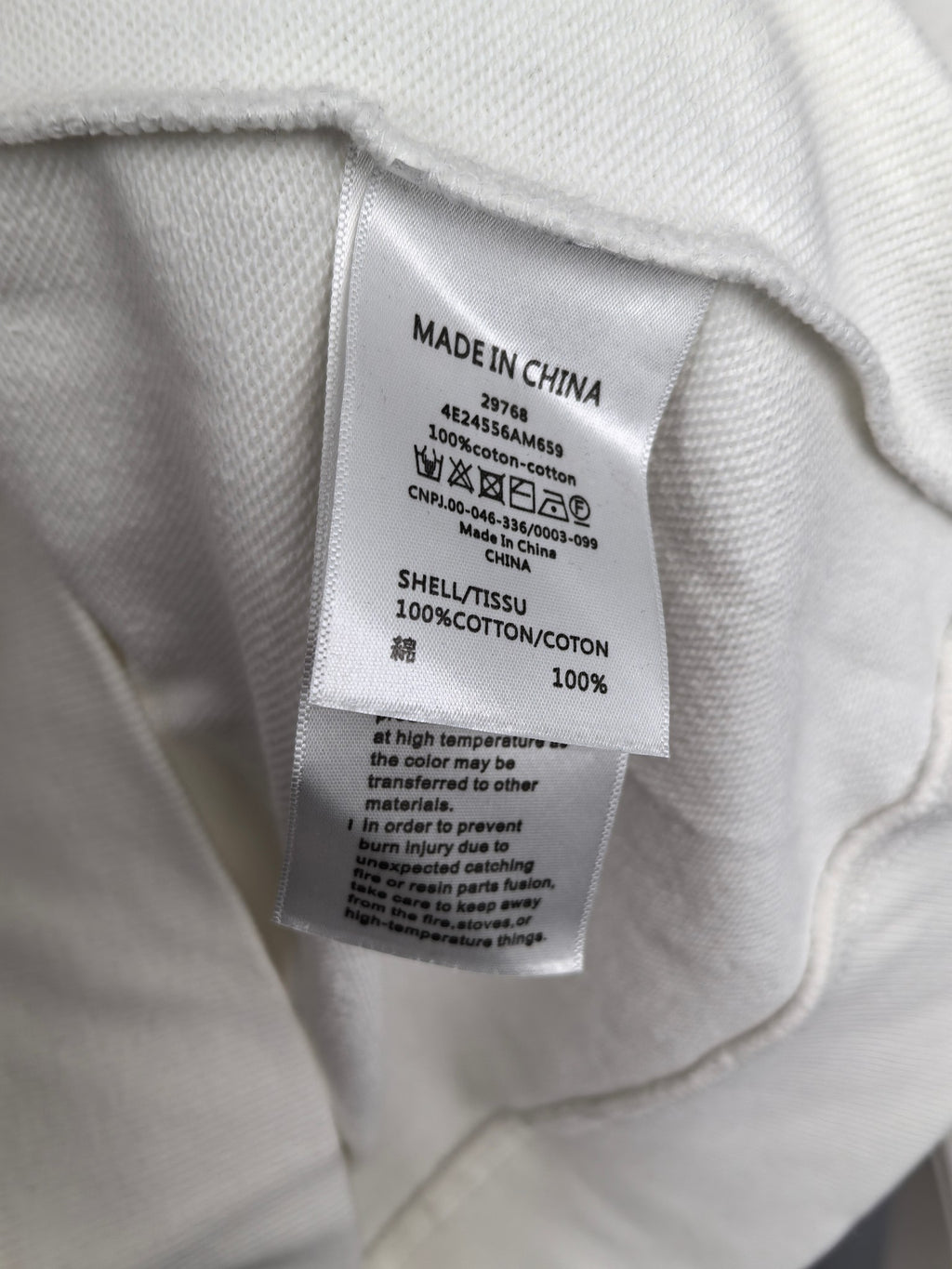 White sweatshirt care label with Made in China and fabric content info