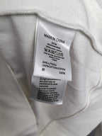 White sweatshirt care label with Made in China and fabric content info