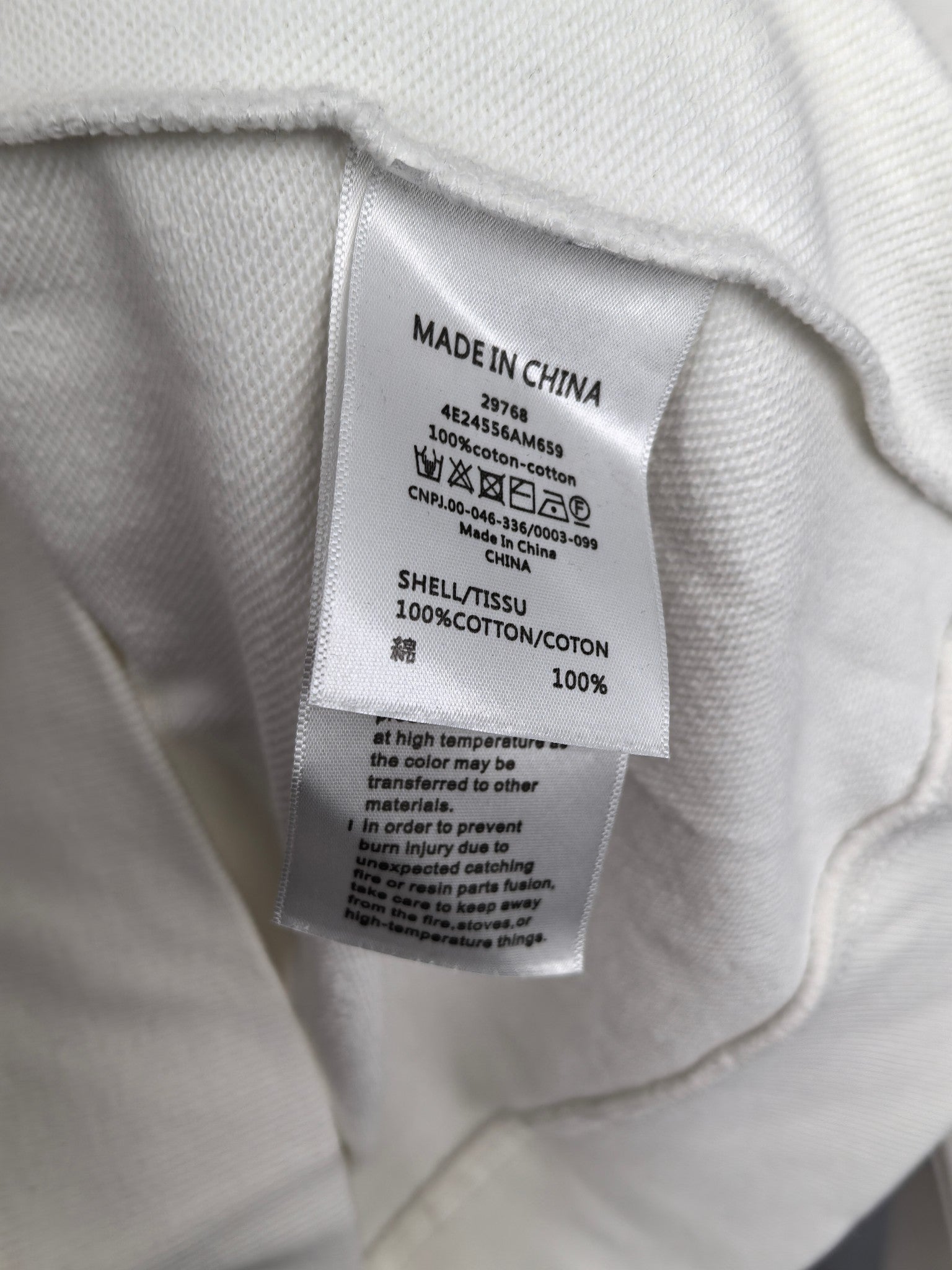 White sweatshirt care label with Made in China and fabric content info