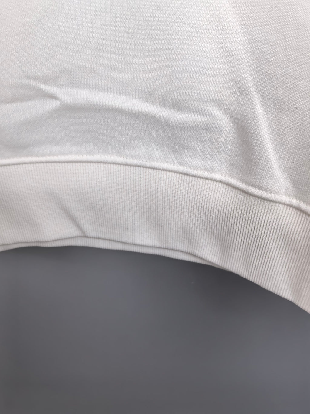 White sweatshirt hem with ribbed trim detail