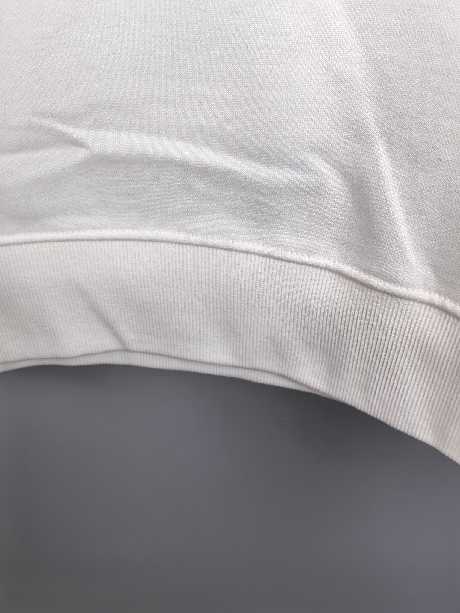 White sweatshirt hem with ribbed trim detail