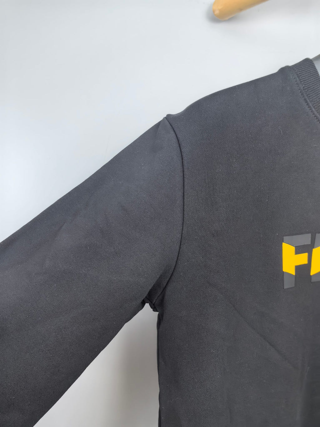 Fendi dark gray sweatshirt sleeve with partial yellow Fendi logo