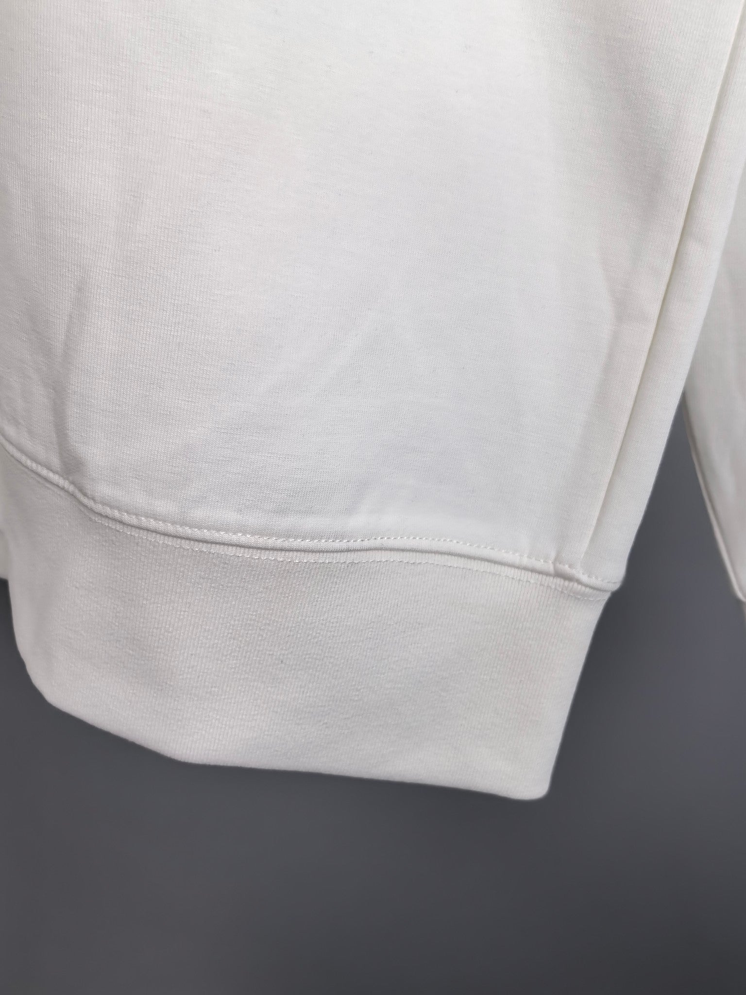 White sweatshirt hem with double-stitched cuff detail