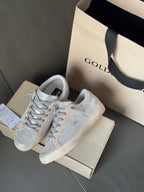 Golden Goose light blue lace-up sneakers on shoebox, suede texture and white outsole