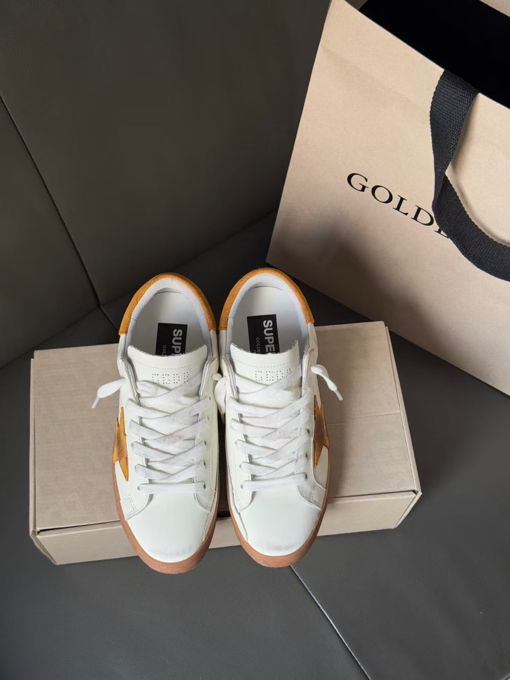Golden Goose low-top sneakers, white lace-up pair with gold star accents