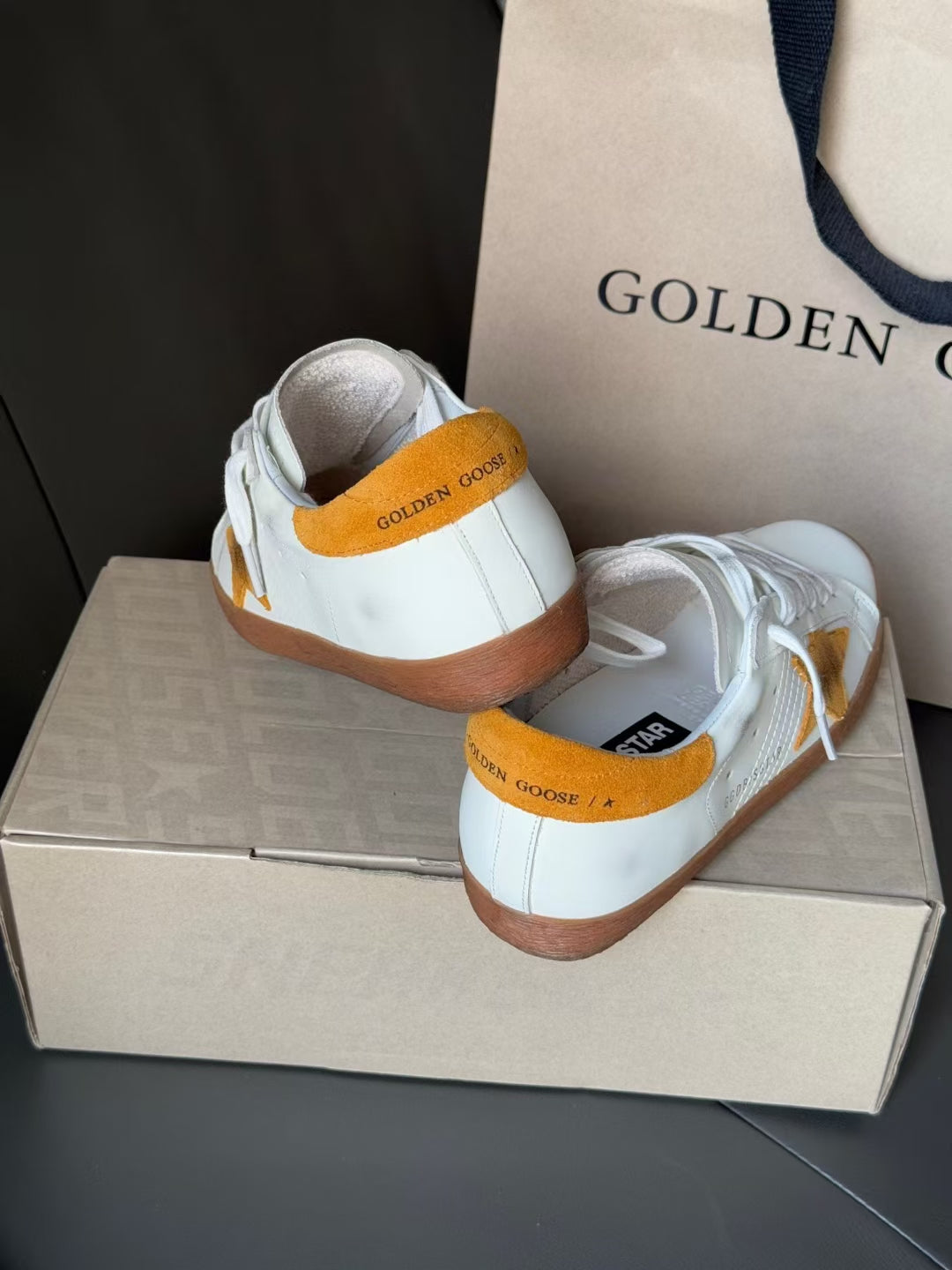 Golden Goose low-top sneakers, white with gold heel label and orange-brown sole