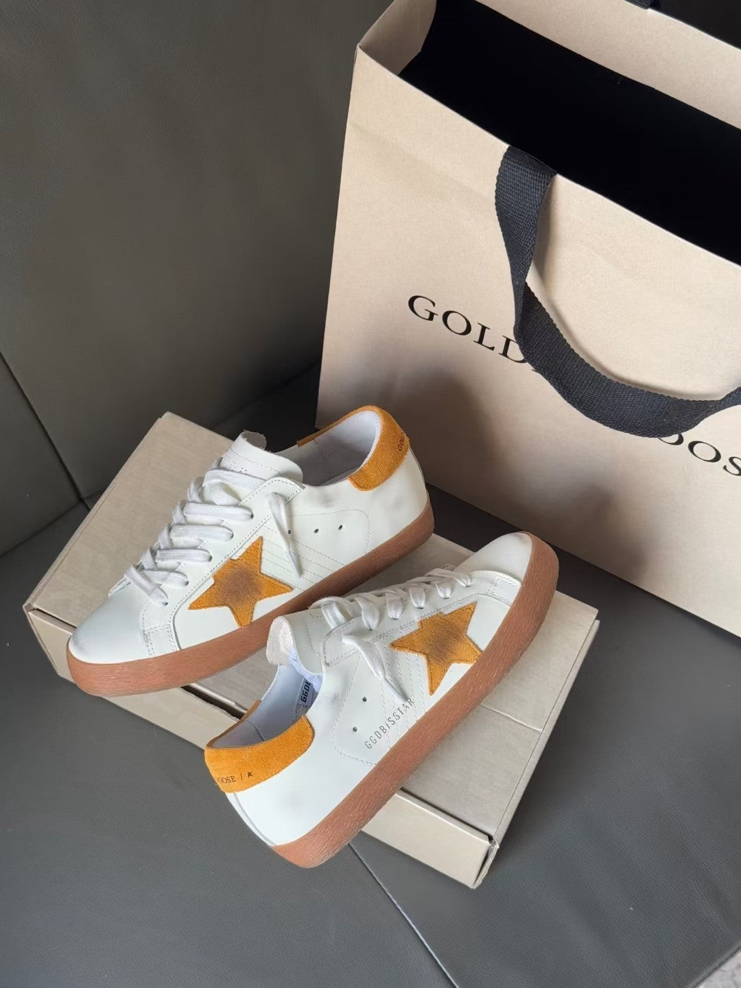 Golden Goose low-top sneakers, front view with gold star on white upper and laces