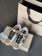 Pair of white leather sneakers with black laces, leopard patch panels, and gold accents.