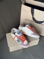 High-top sneakers on shoebox, orange laces, white and lilac color-block design