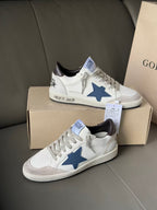 Pair of white low-top sneakers with blue star emblem and lace-up design