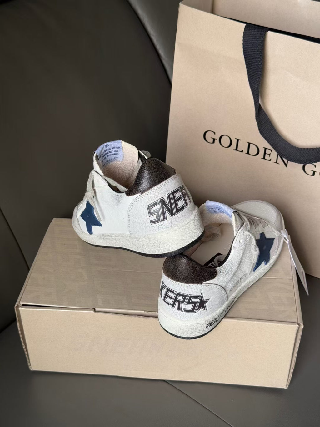Back view of white low-top sneakers with blue star patch and black collar