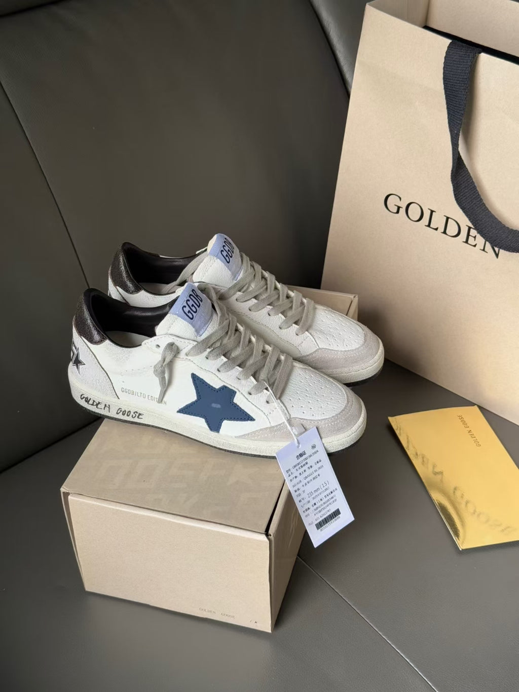 White leather sneakers with blue star patch and black heel lining, lace-up front