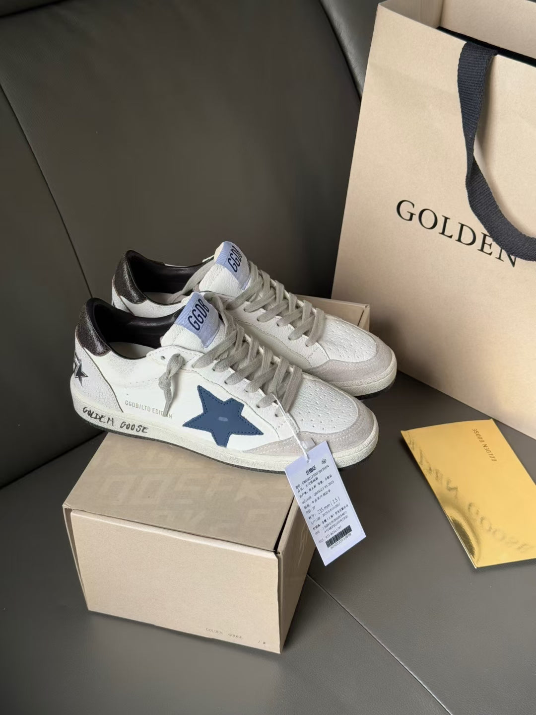 White leather sneakers with blue star patch and black heel lining, lace-up front