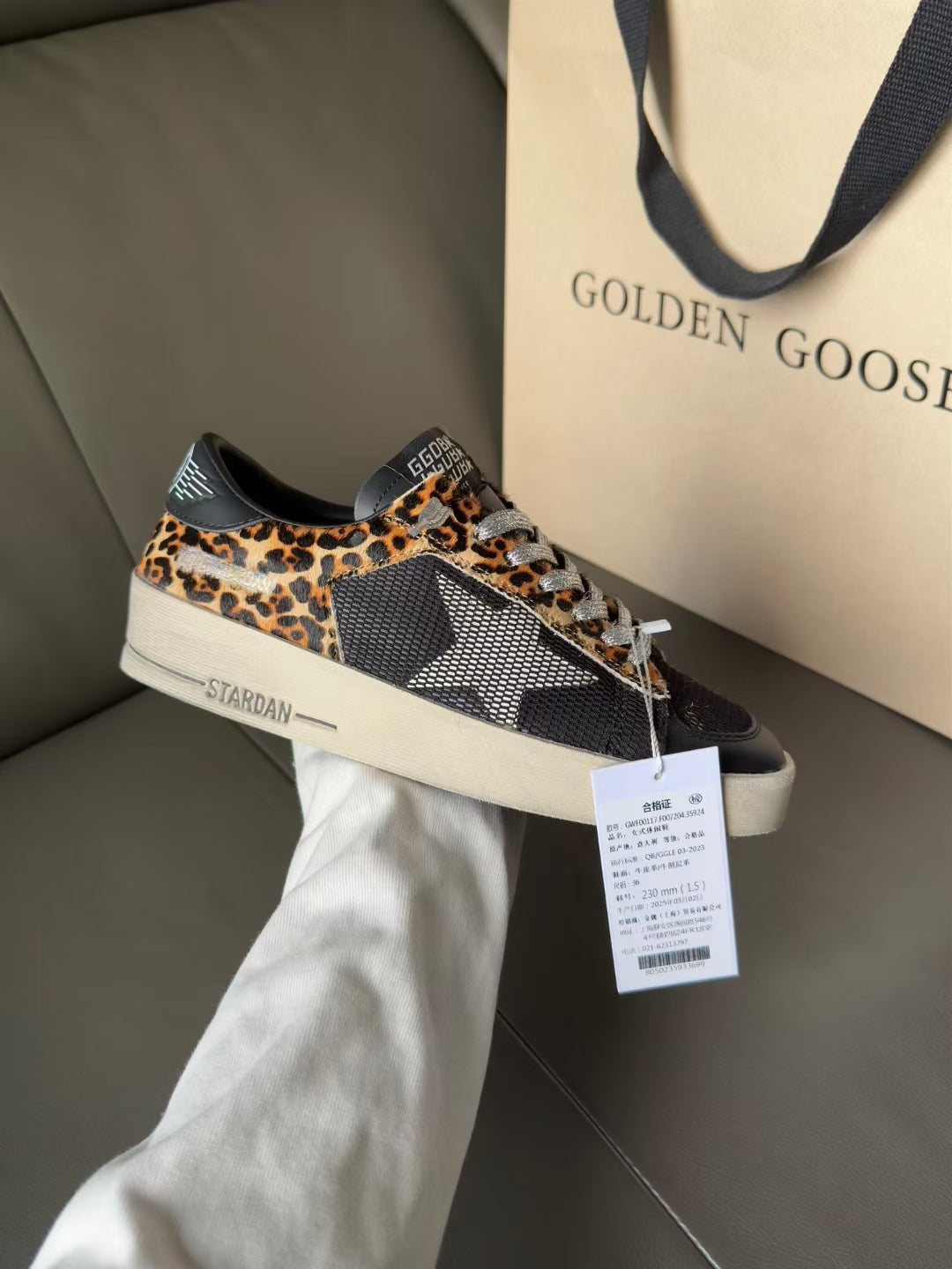 Low-top lace-up sneakers with leopard-print panels, dark uppers, and white rubber sole