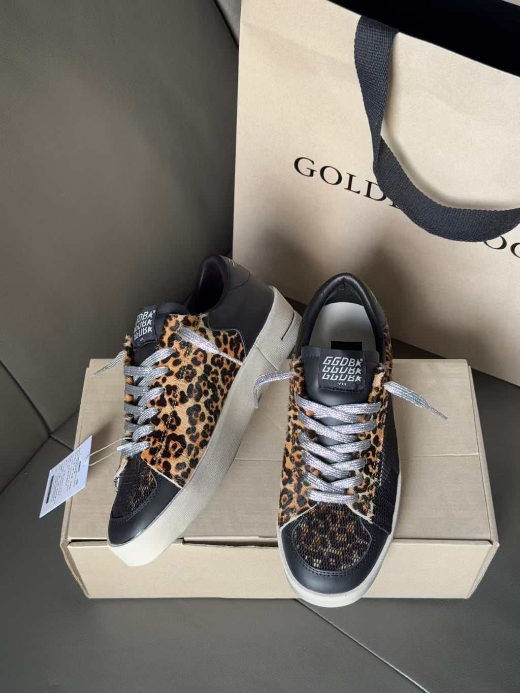 Golden Goose lace-up sneakers pair, navy with leopard-print sides and white laces