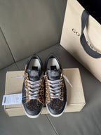 Pair of low-top leopard-print sneakers with dark uppers and white lace-up trim