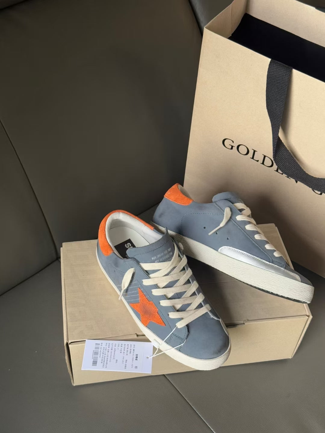 Golden Goose low-top sneakers with orange star patch, light blue upper, white sole