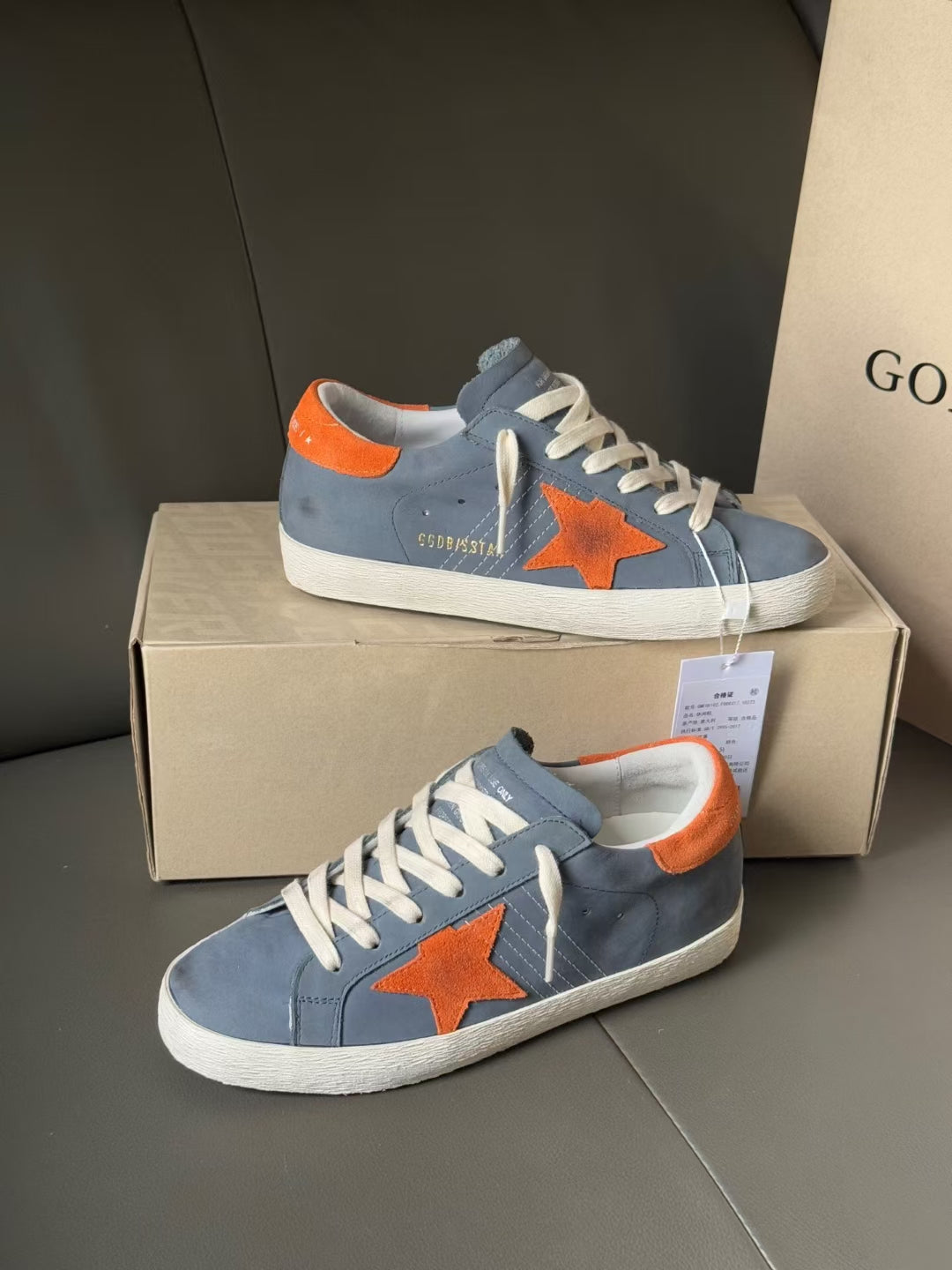 Golden Goose low-top sneakers in blue with orange star graphic and orange collar lining.
