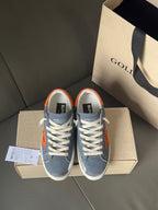 Golden Goose lace-up sneakers in blue with orange star accents and white midsoles.