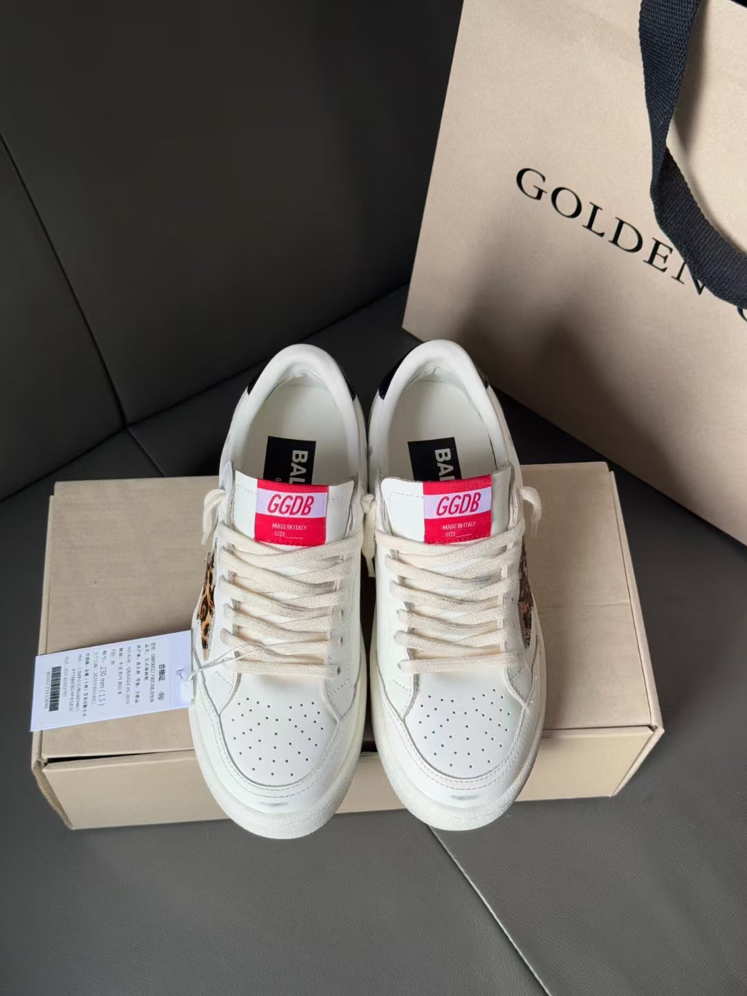 White leather sneakers pair with red and blue tongue labels