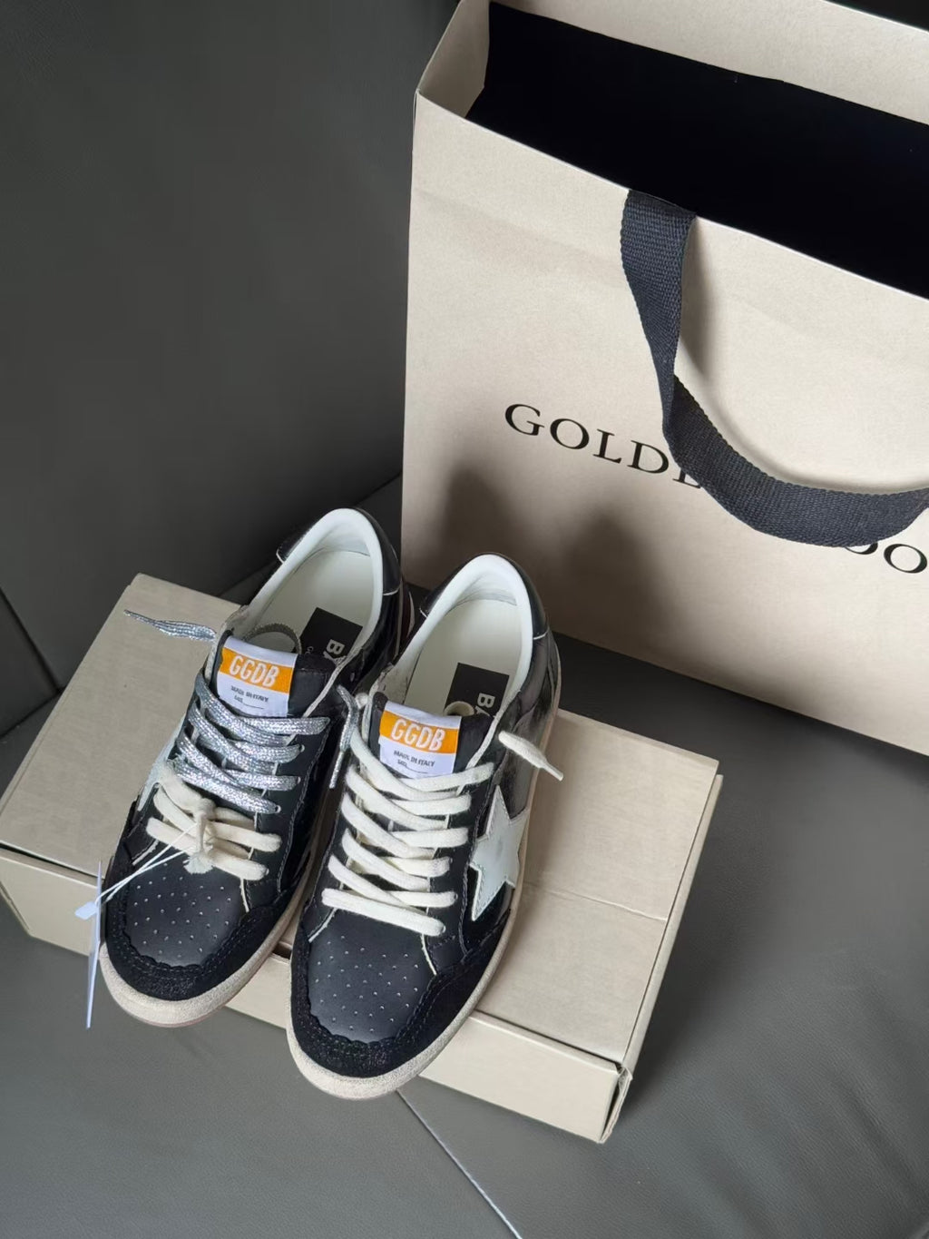 Low-top sneakers on shoebox, navy upper with white star, lace-up, gum sole