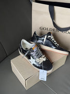 Side view low-top sneakers, dark navy with white star, lace-up, gum sole, in box