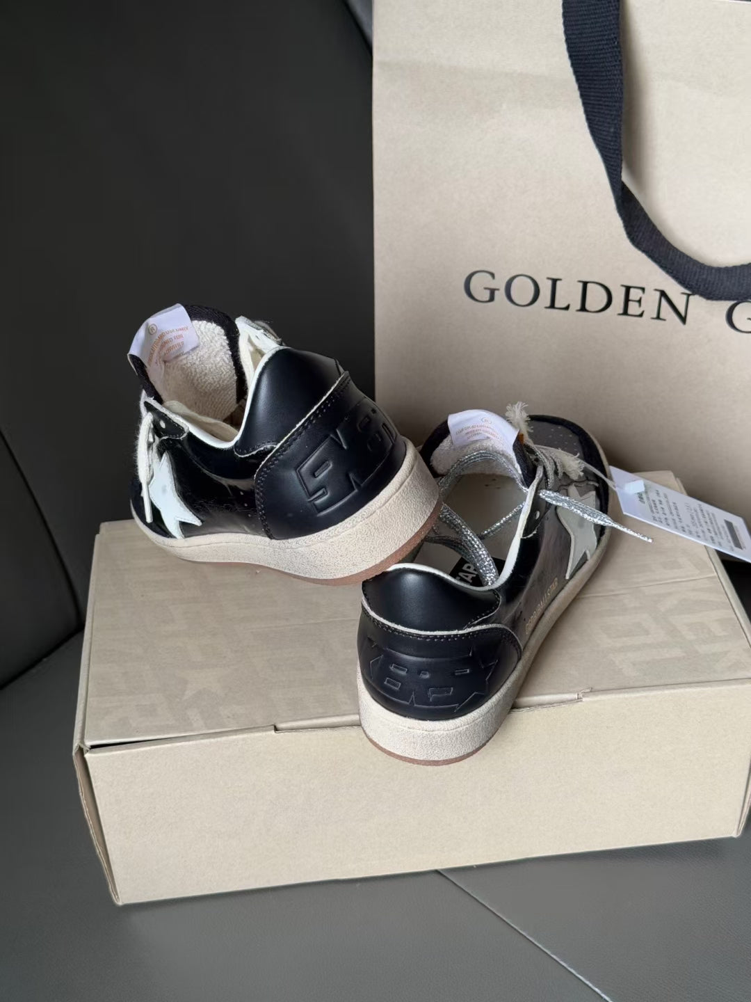 Back view low-top sneakers, dark navy with white star, lace-up, gum sole on shoebox
