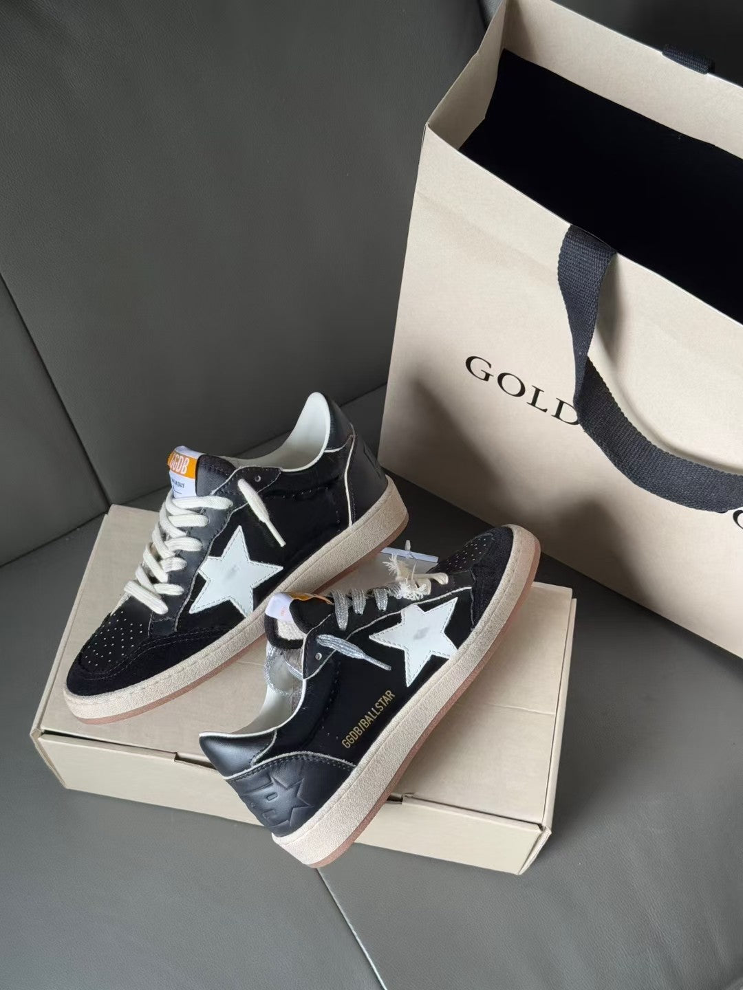 Low-top sneakers, dark navy with white star, lace-up, gum sole, on shoebox