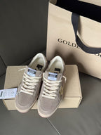 Pair of Golden Goose low-top sneakers on box, light gray upper and white laces