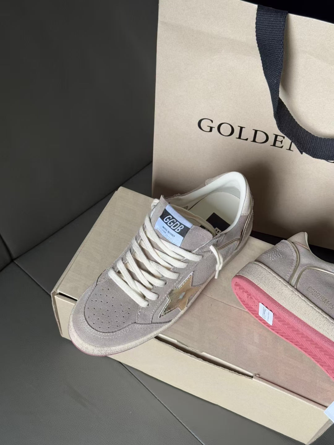 Light gray low-top sneakers with white laces, metallic star logo, pink side stripe