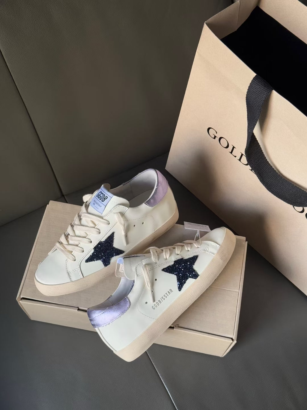 Two luxury sneakers, white leather look with navy star and lavender heel lining