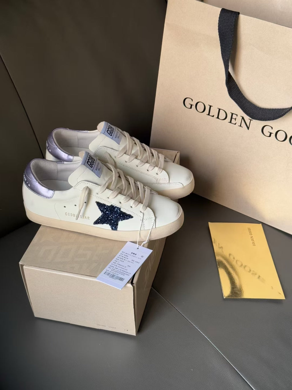 Luxury sneakers in white with navy star and lavender heel, lace-up, on boxes