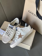 White leather sneakers with gold glitter star and dark glitter heel accent