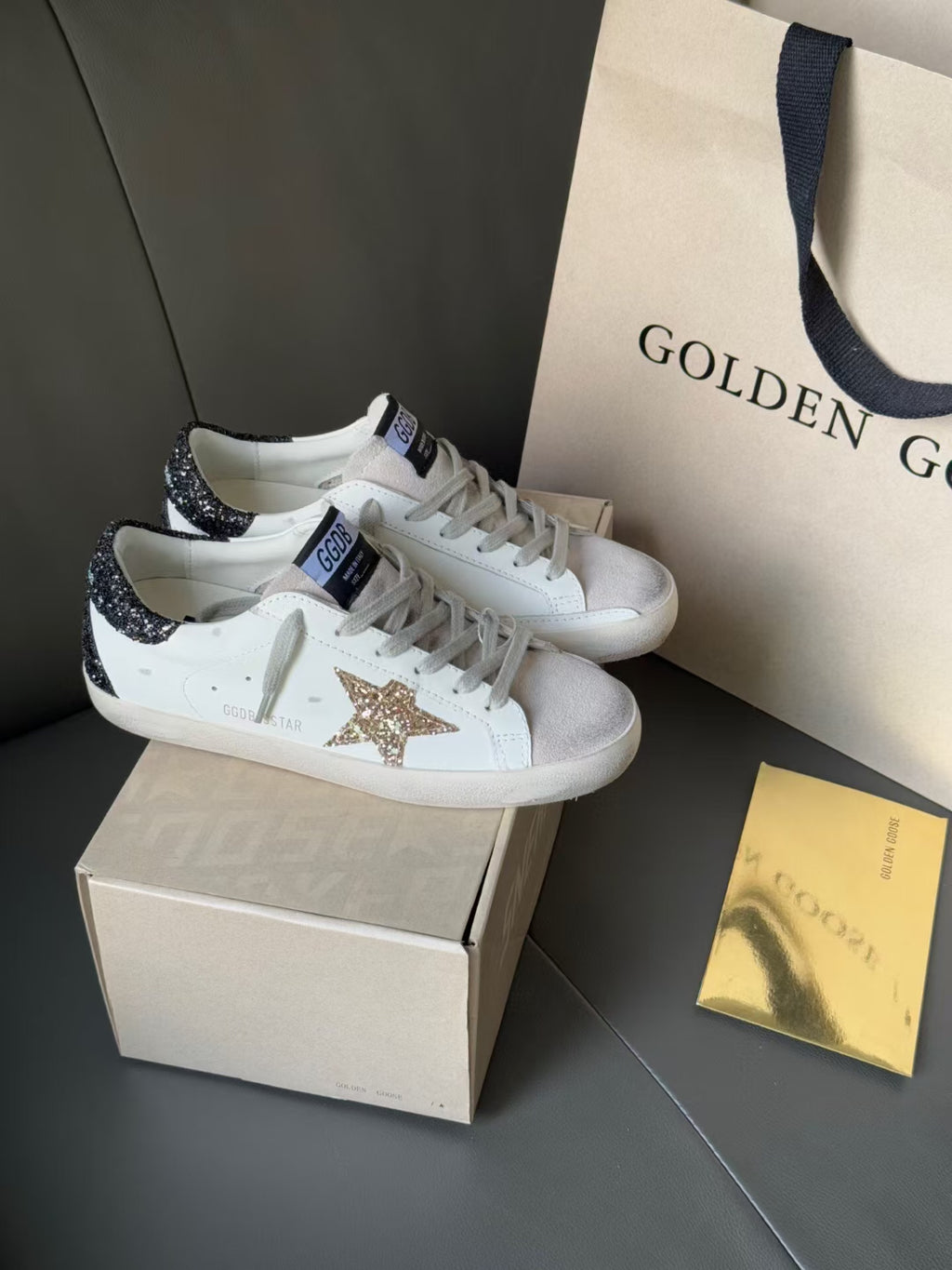 White sneakers with gold glitter star front and dark glitter side panels
