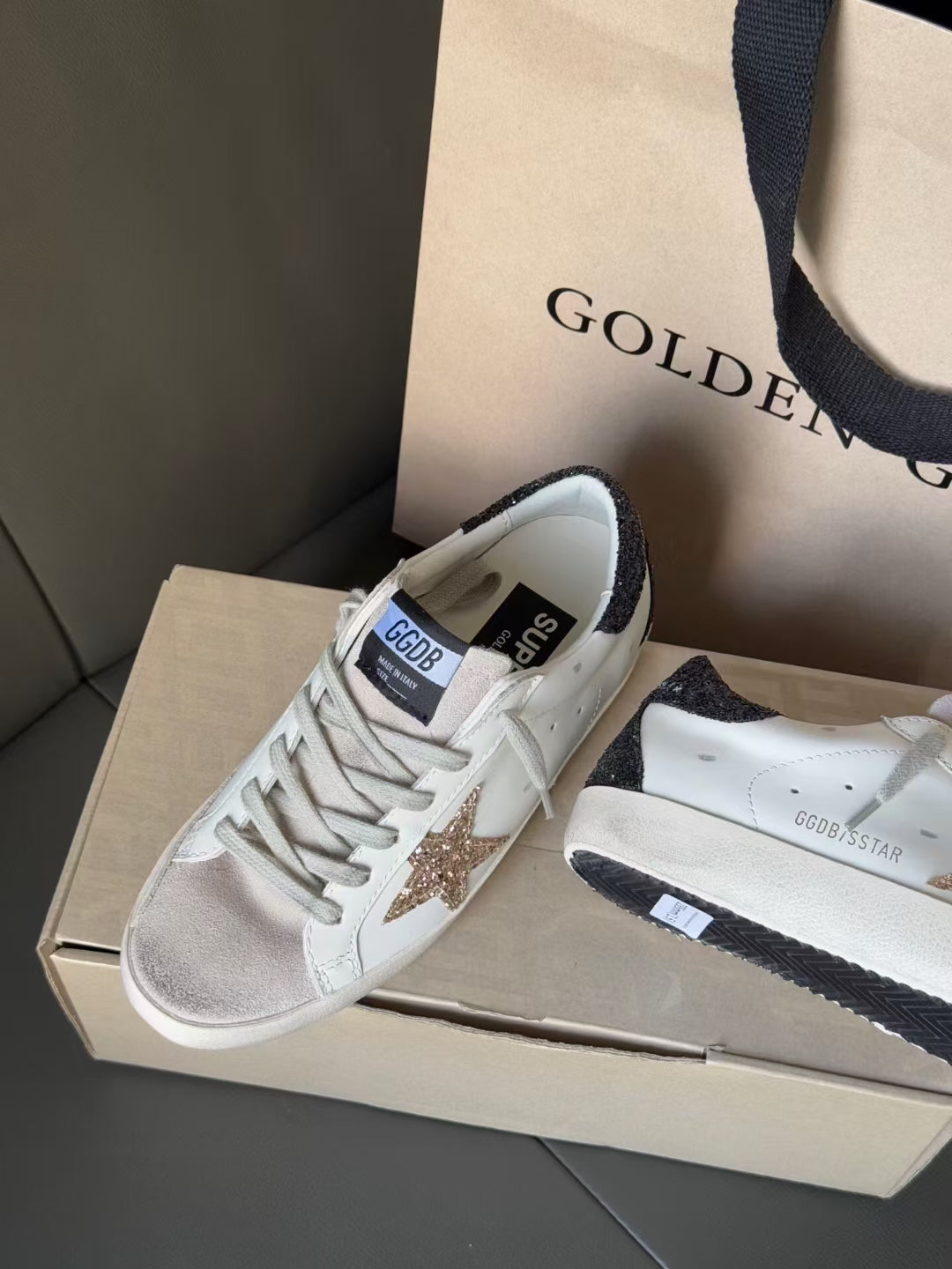 White sneakers with gold star and dark heel trim, shown with matching pair