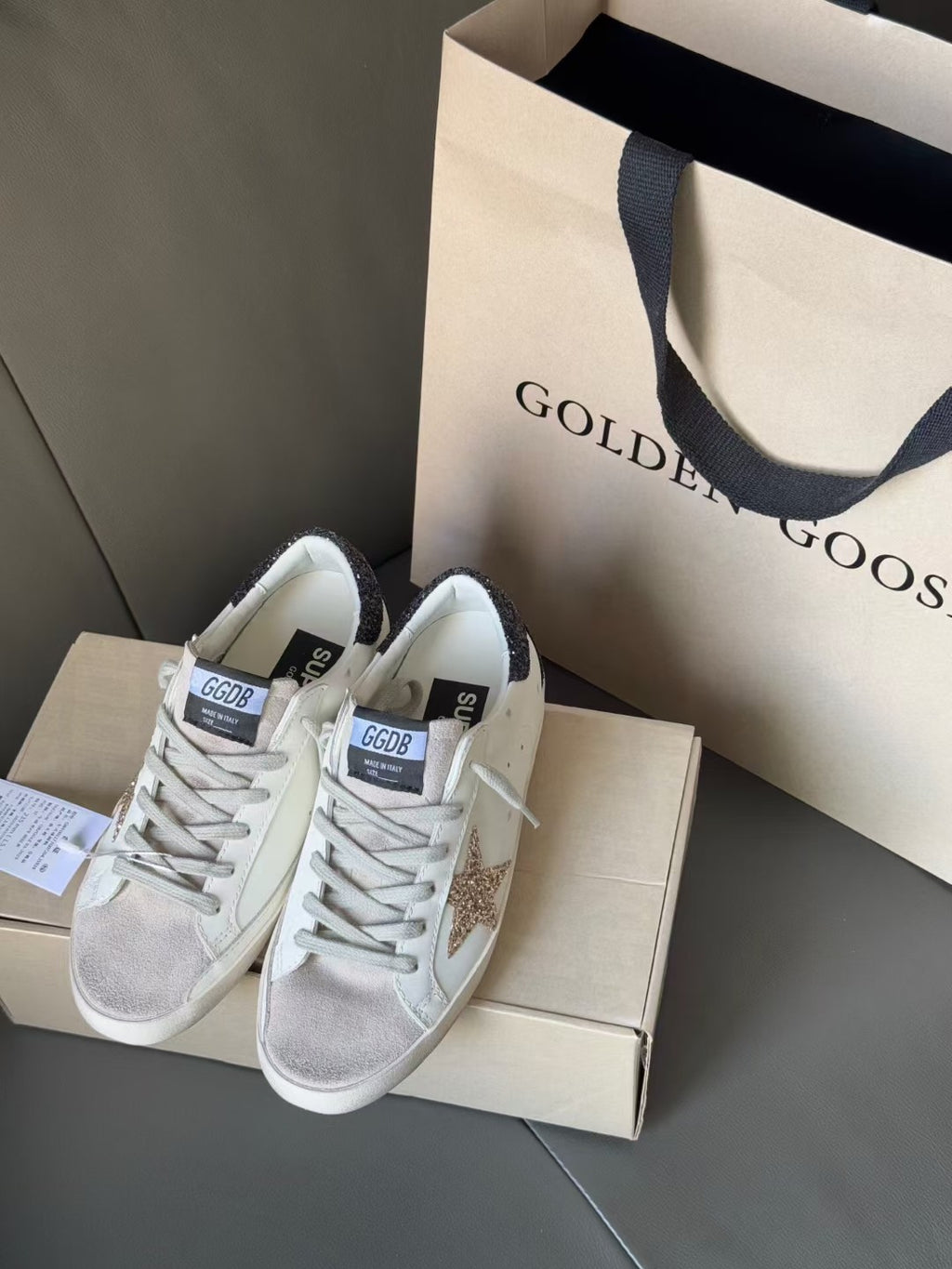 White low-top sneakers with gold glitter star and dark glitter heel tabs