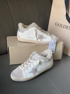 White lace-up sneakers with glitter star panels and soft shearling lining, on box