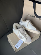 White sneakers with glitter star side panels and lace-up closure, shown with shoe box