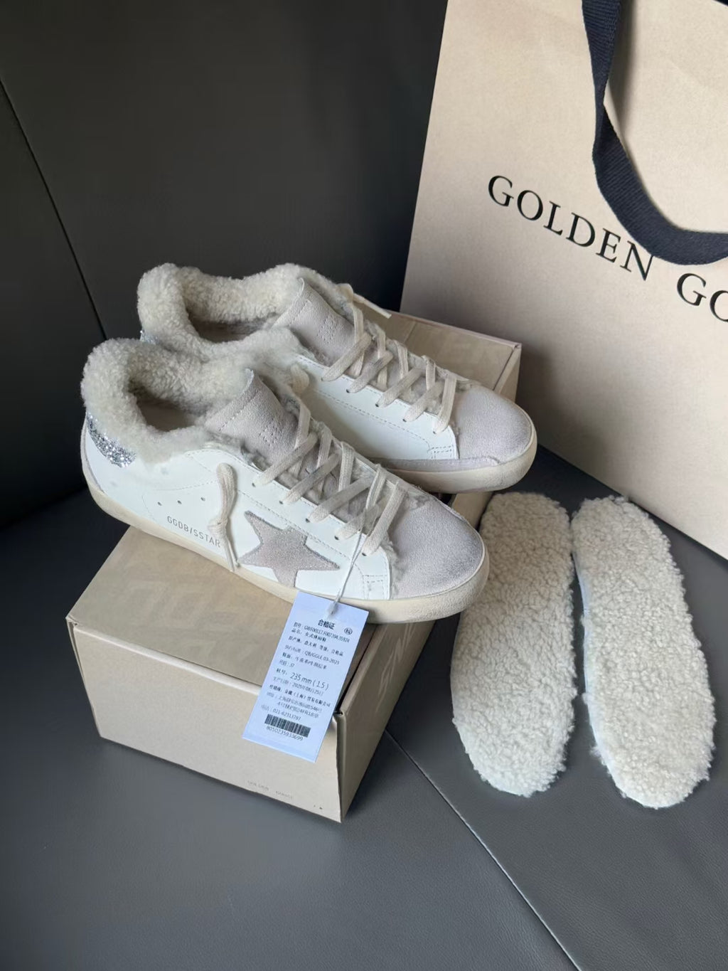 White sneakers with glitter star side panels and plush collars, next to fuzzy shoe liners