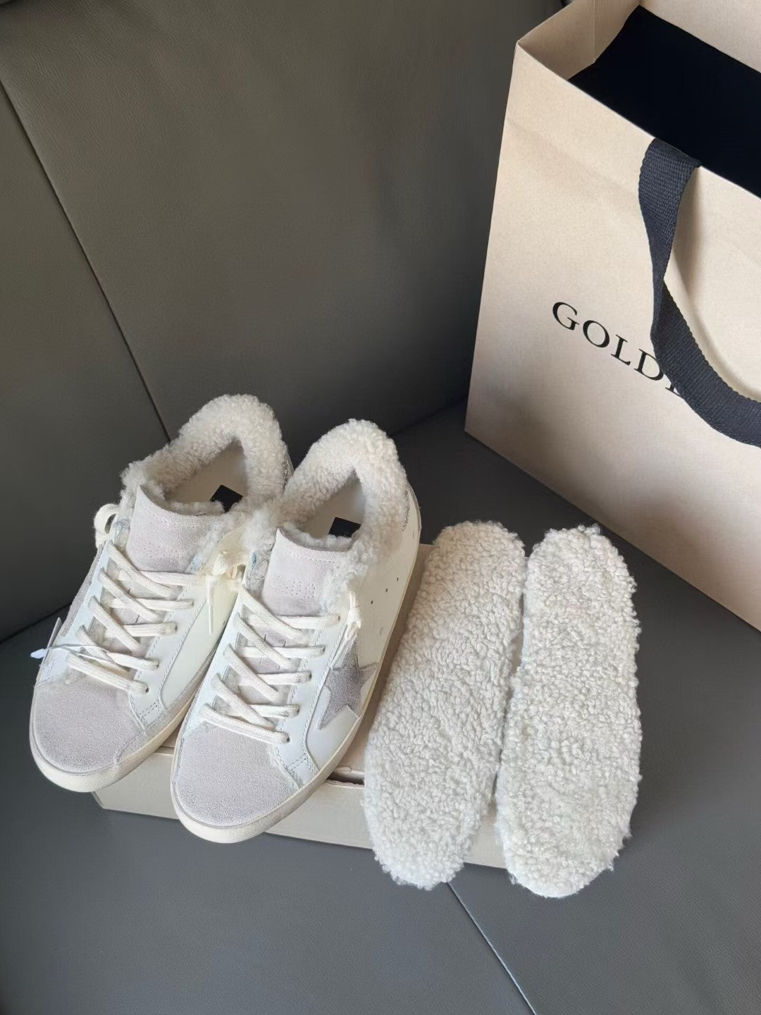 White sneakers with shearling cuffs and glitter star details, with matching plush slippers