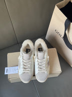 White sneakers with plush lining and lace-up closure, shown from the front on boxes