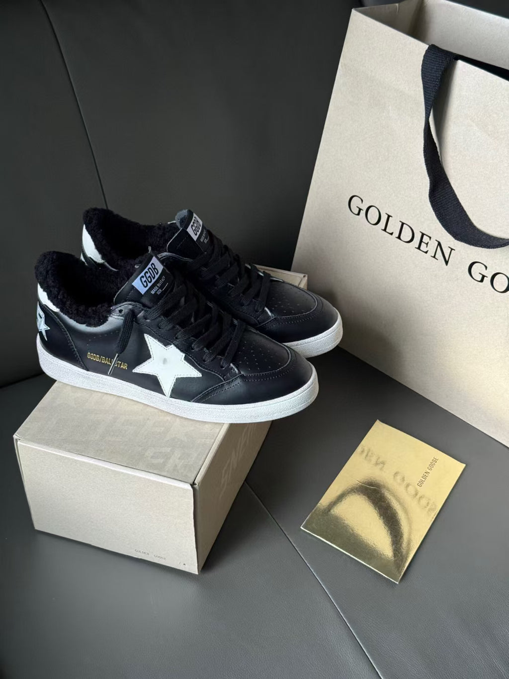 Black low-top sneakers with white sole, star side panels, and lace-up uppers