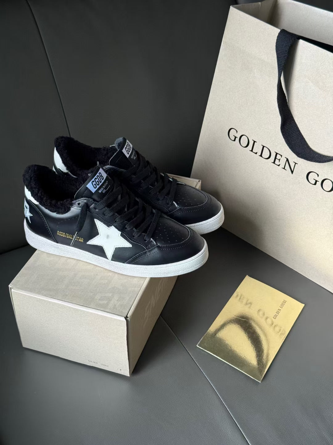 Black low-top sneakers with white sole, star side panels, and lace-up uppers