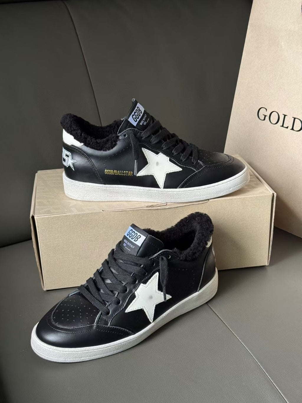 Black low-top sneakers with white star patch, lace-up front, white rubber sole