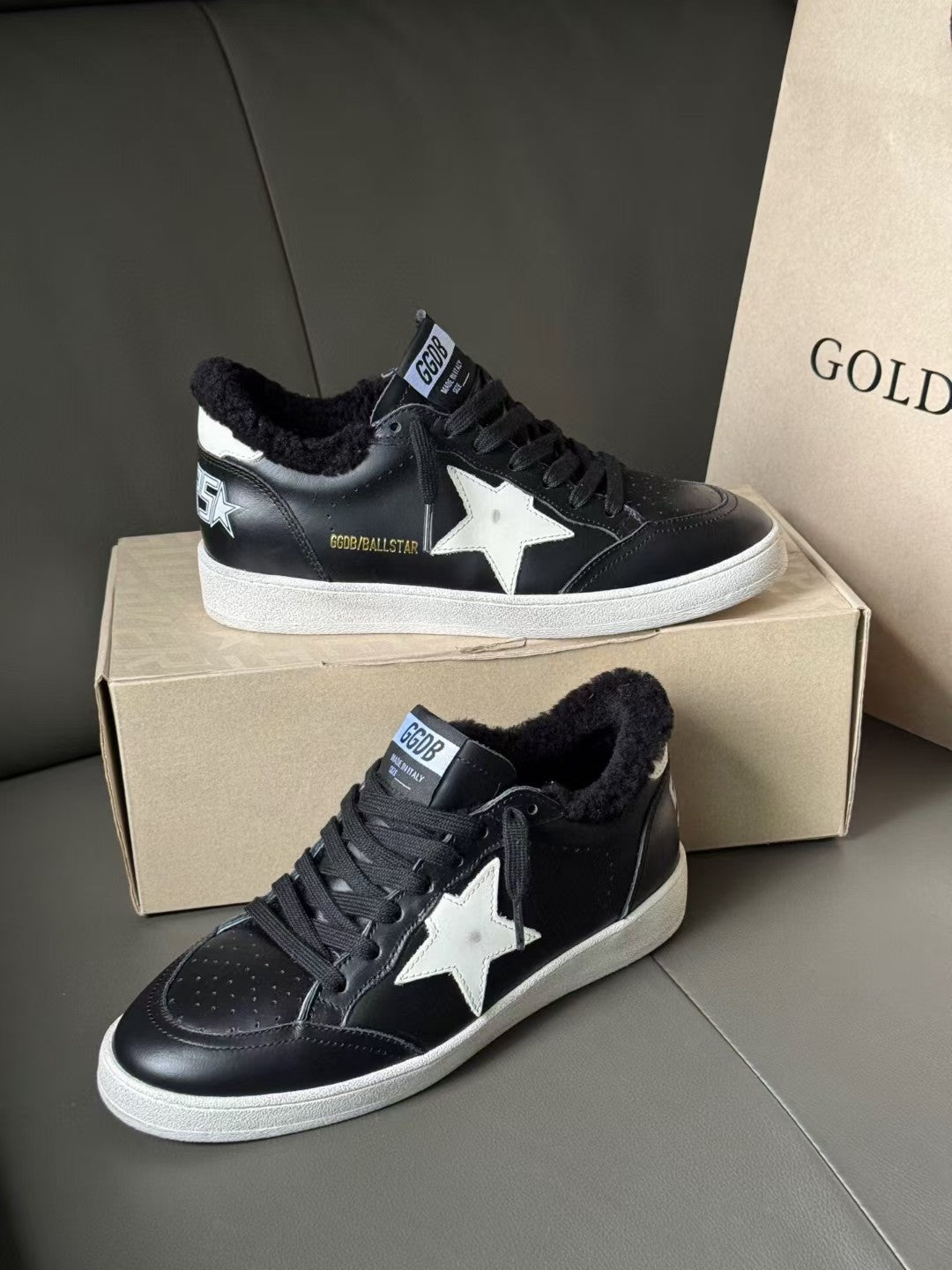 Black low-top sneakers with white star patch, lace-up front, white rubber sole