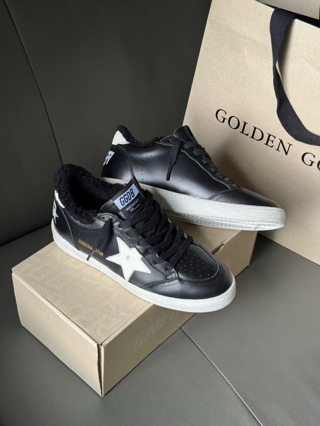 Black low-top sneakers with white star side logo and perforated toe details